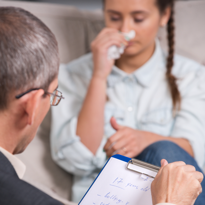 therapist is taking notes during therapy session