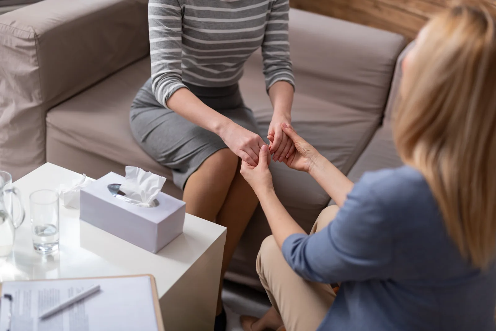 Therapist reassuring a client in a calm therapy office