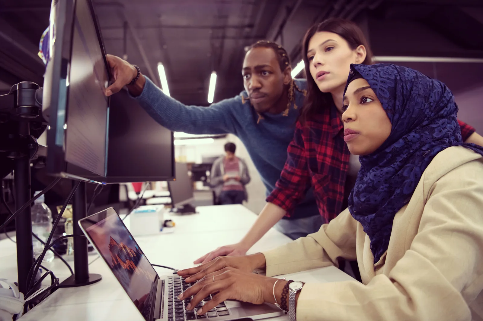 SaaS product team reviewing work on a monitor together