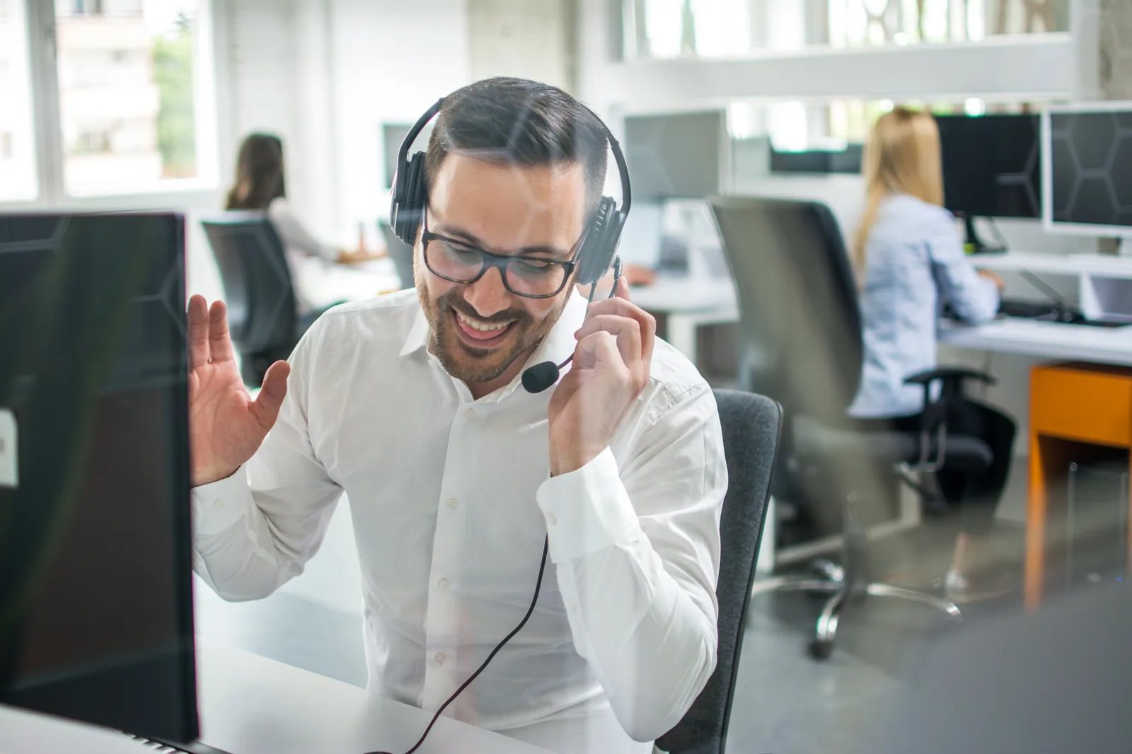Sales rep on a headset call in a busy office